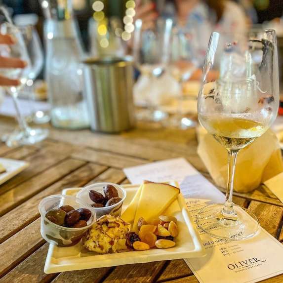 A table of women enjoying wine and charcuterie plates at Oliver Winery