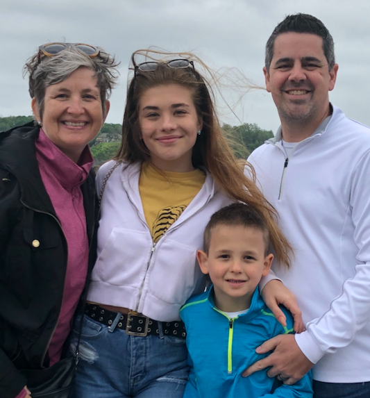 Julie Kirkpatrick, CEO of meetNKY, smiling at the camera with her family