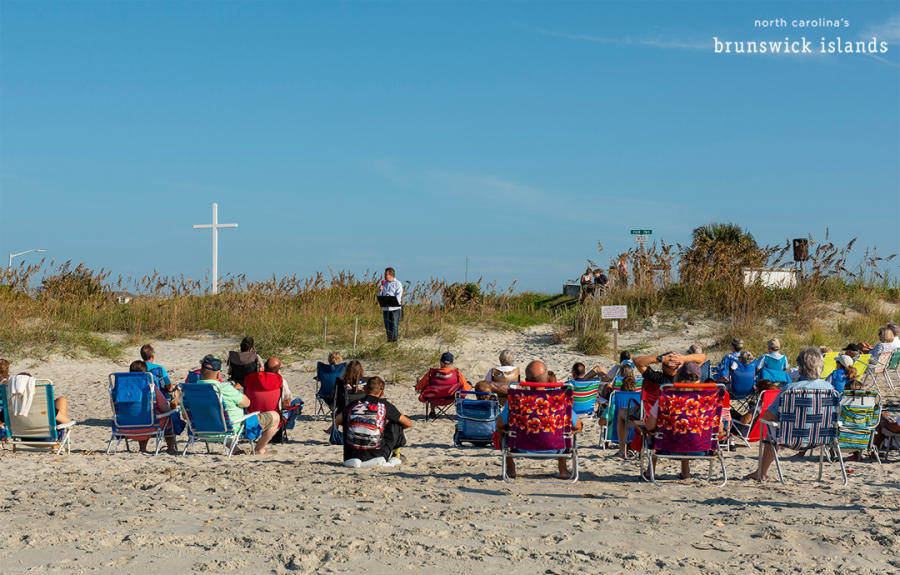 a group of people sitting in beach chairs listening to a sermon