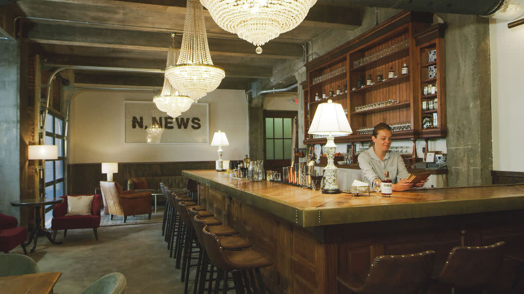Ironclad Distillery Lobby - N. News Sign Hangs in Back with Bar and chandelier taking up most of the space