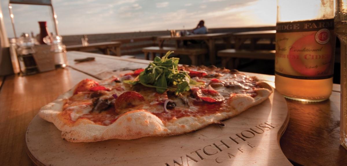 Pizza on a wooden board at Watch House Cafe, Dorset