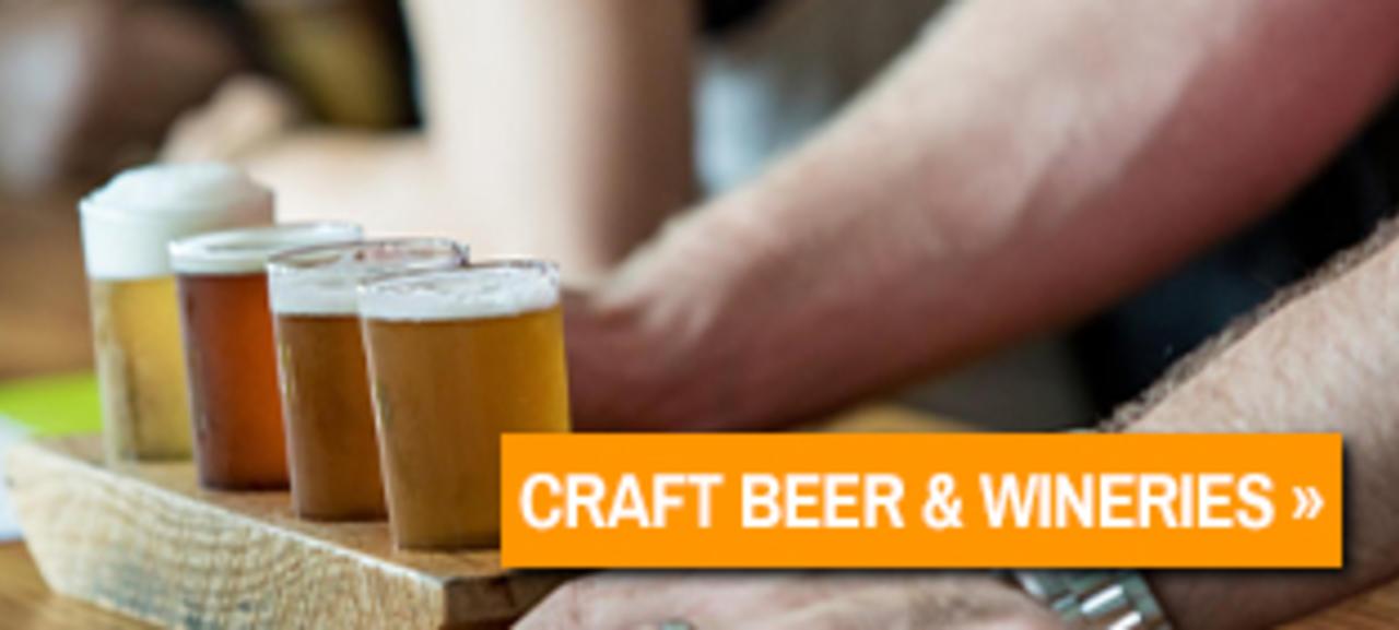 A flight of various craft beers on a wooden plank at a brewery in New Braunfels.