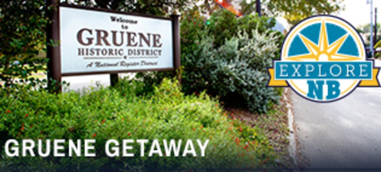 A large sign reading "Welcome to Gruene Historic District" is nestled among beautiful greenery in Gruene, Texas. The photo is accompanied by the "Explore NB" logo.