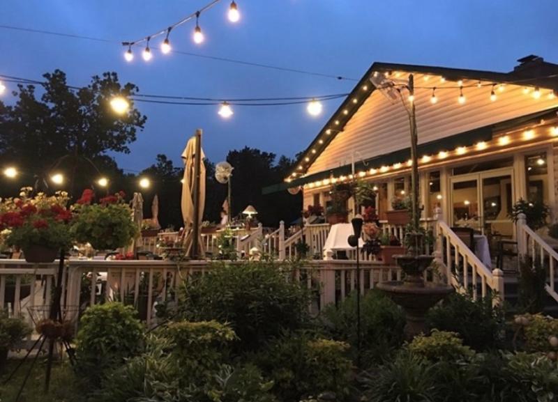 restaurant at dusk with string lights lining the outdoor dining porch