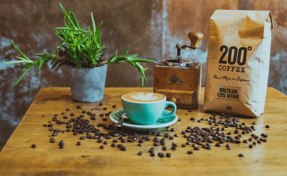 A table with coffee beans scattered around a cup of coffee