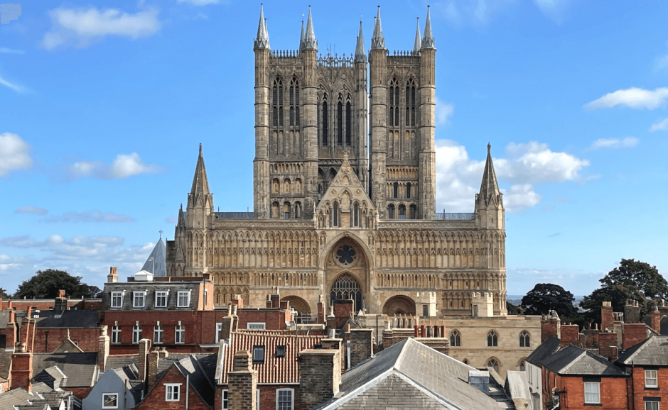 View of Lincoln Cathedral and its three towers over roof tops in Lincoln