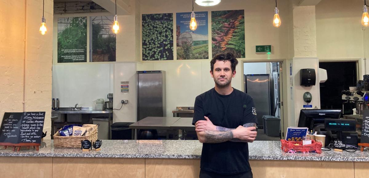 The owner of the Hive standing in front of the counter