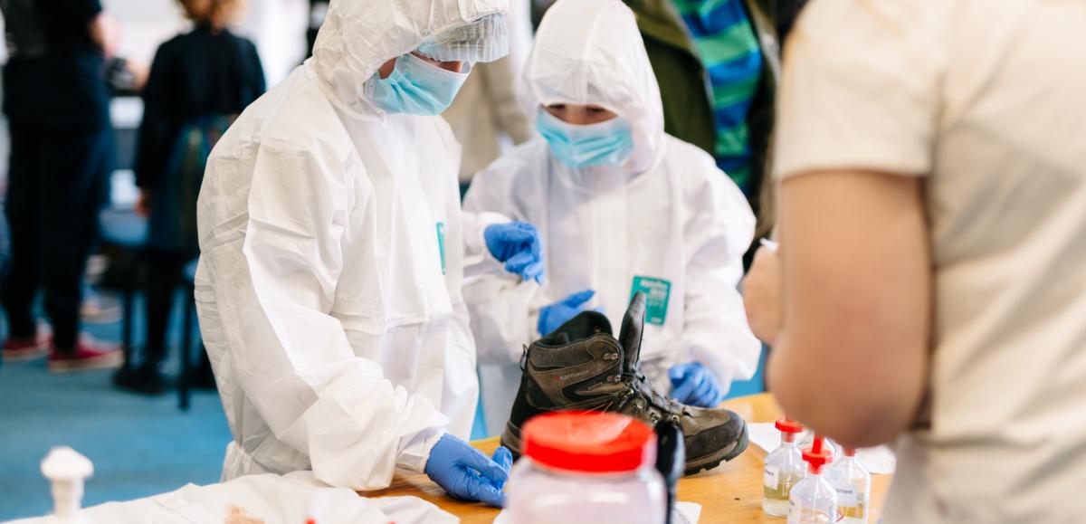 Two children in which suits and masks study a reaction
