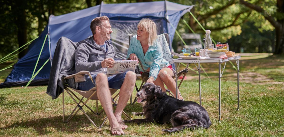 Couple and dog camping in tent in the New Forest