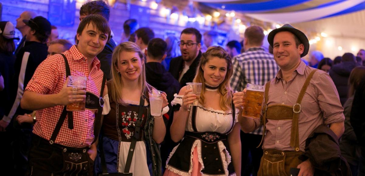Group of friends raising their stein glasses of beer at Southampton Oktoberfest