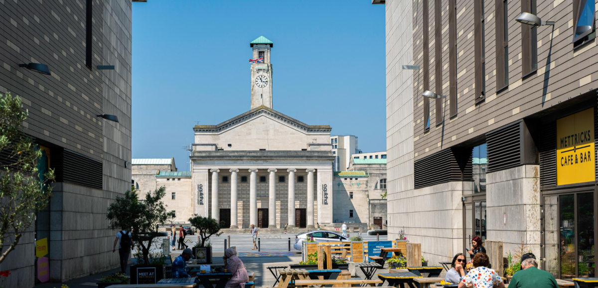 O2 Guildhall building in background with cafe tables and chairs in foreground on a sunny day