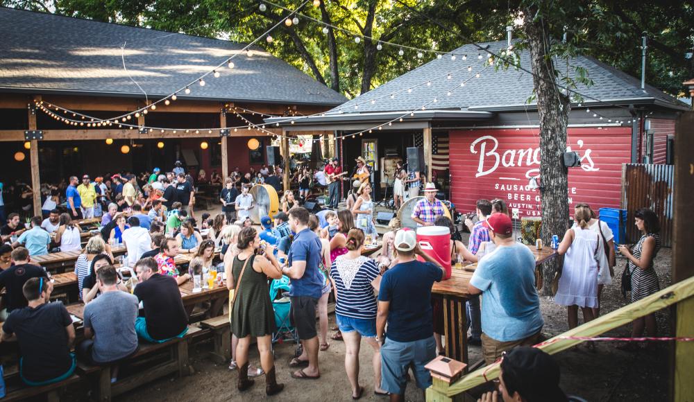 People gathering on patio at Bangers Sausage House and Beer Garden on Rainey Street in Austin Texas