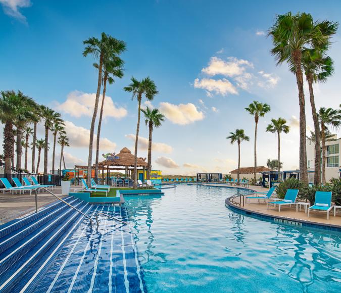 Clear blue pool with tropical setting facing the beach