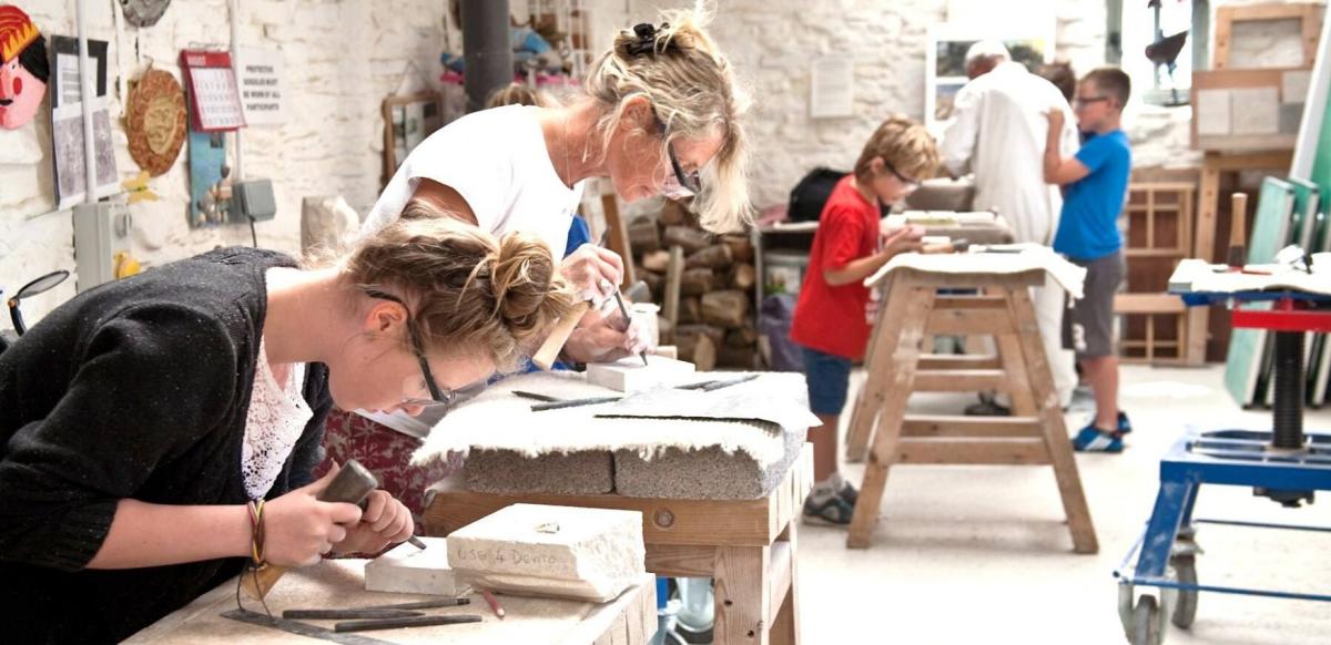 A group of people carving stone at Burngate Stone Carving Centre