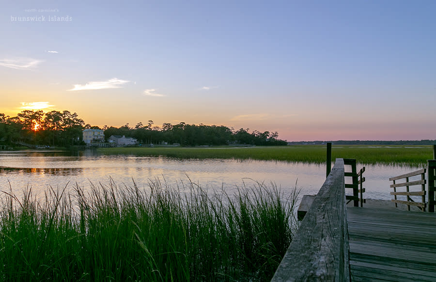 A wooden boardwalk leading to a dock in the marsh on Oak Island