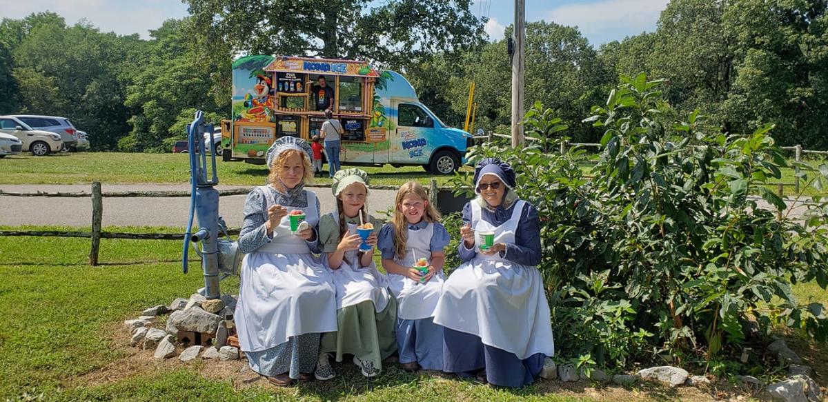 4 girls in 1800s dresses eating popscicles