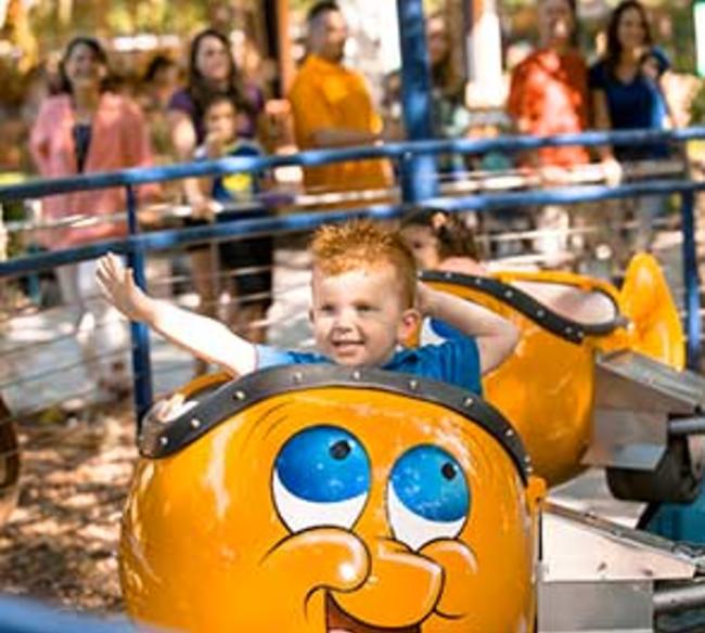 Little boy waving as he rides Bulgy the Goldfish