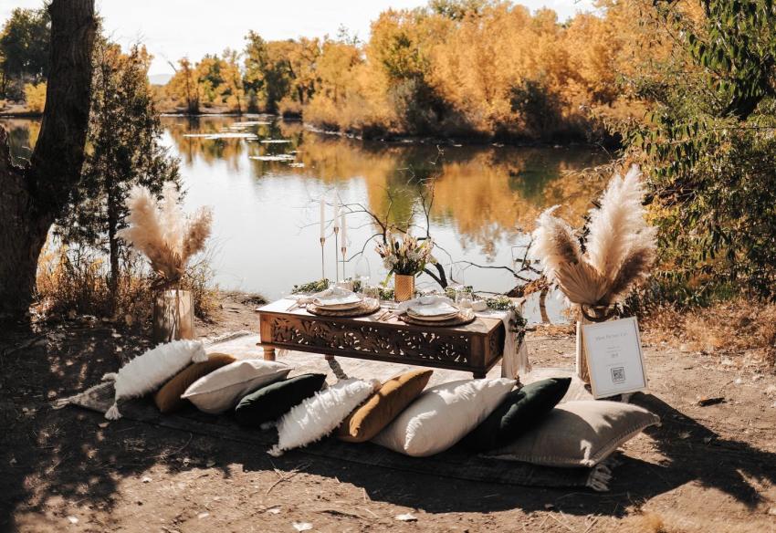 Mod Picnic Setup by river with pillows for seating and artful place settings