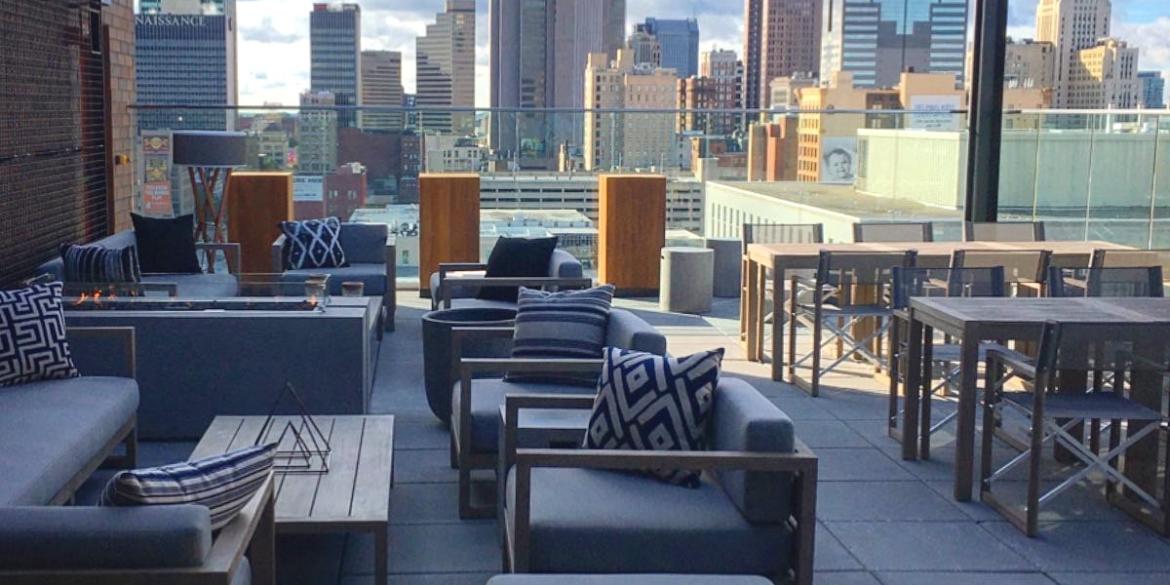 City skyline views and chic patio furniture on stylish rooftop bar at Goodale Station at Canopy by Hilton