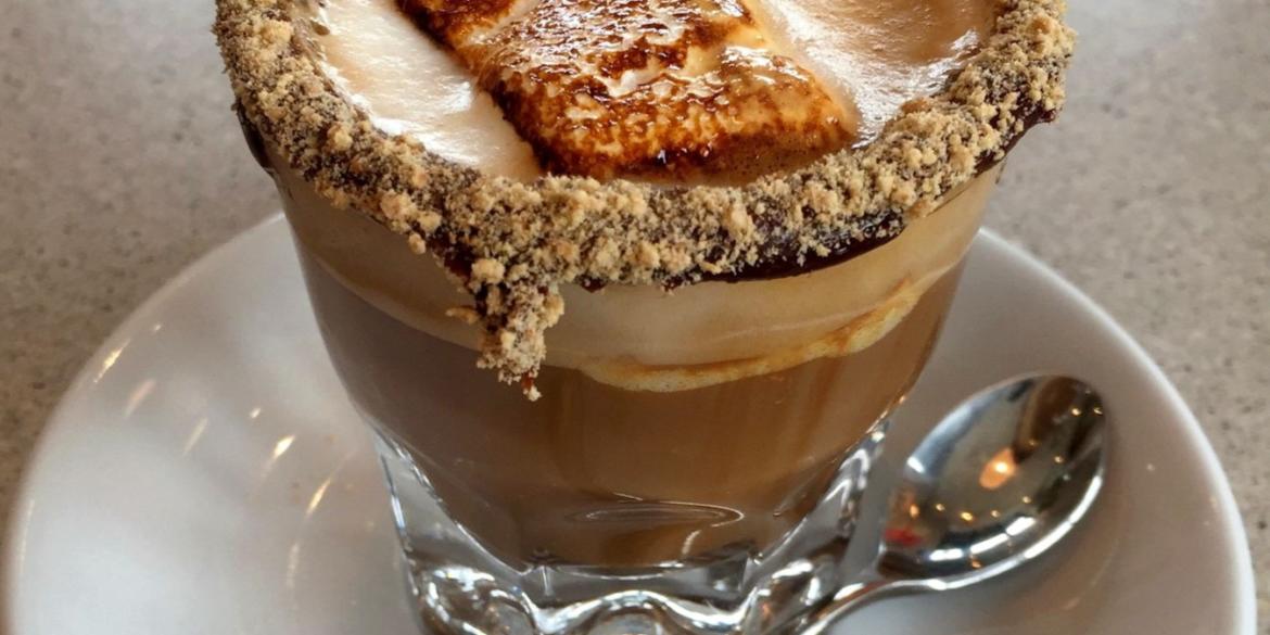 Kittie's Cakes' Smortado coffee pictured on saucer with spoon, marshmallow and gram cracker-crusted rim