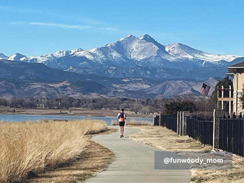 Woman running with Long's Peak in the background
