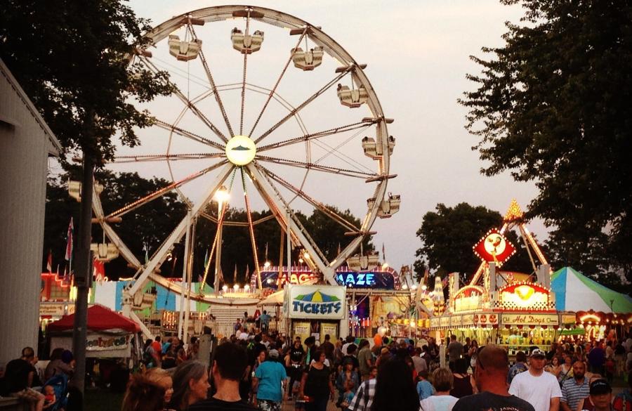 Crowd by food vendors and ferris wheel at the Monroe County Fair