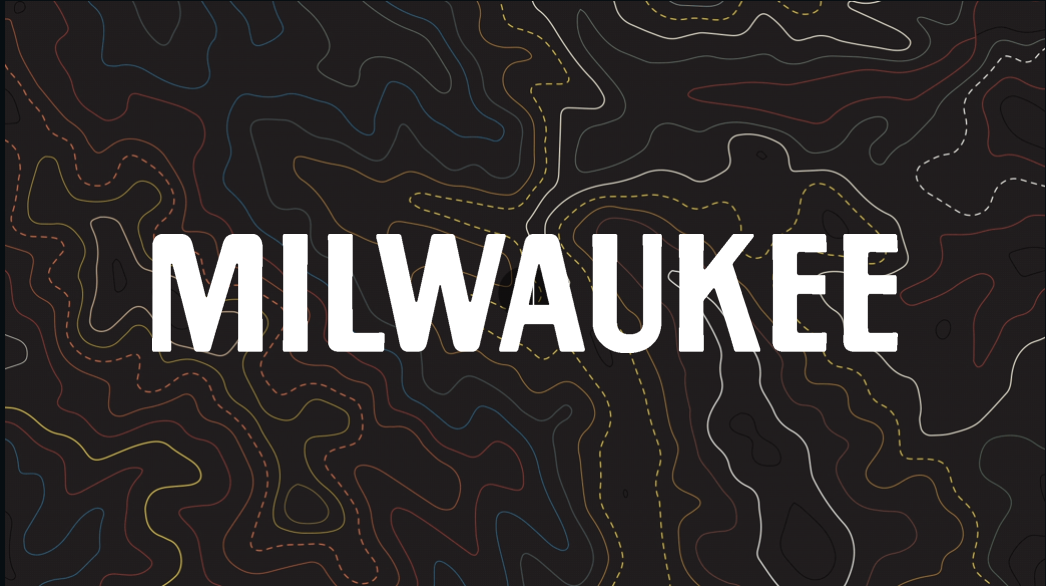 The word “MILWAUKEE” stacked in three lines reading “MIL WAU KEE” in bold white letters over a dark background filled with colorful topographic contour lines.