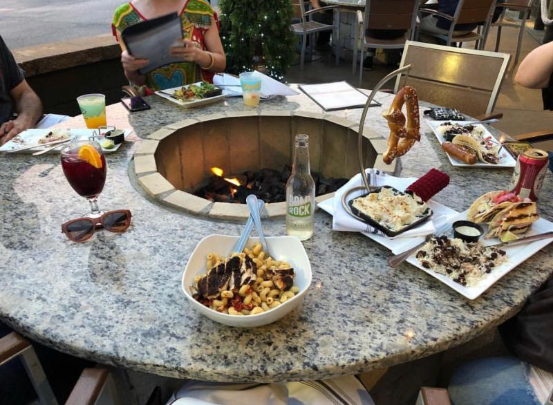 outdoor fire pit with seating and people eating