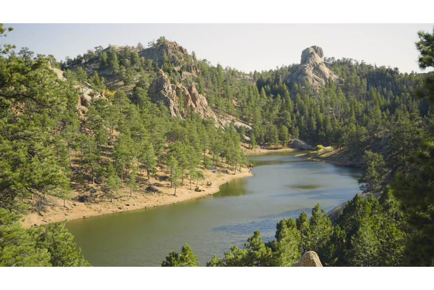 Scenic view of Curt Gowdy State Park with pine-covered hills and a serene lake.