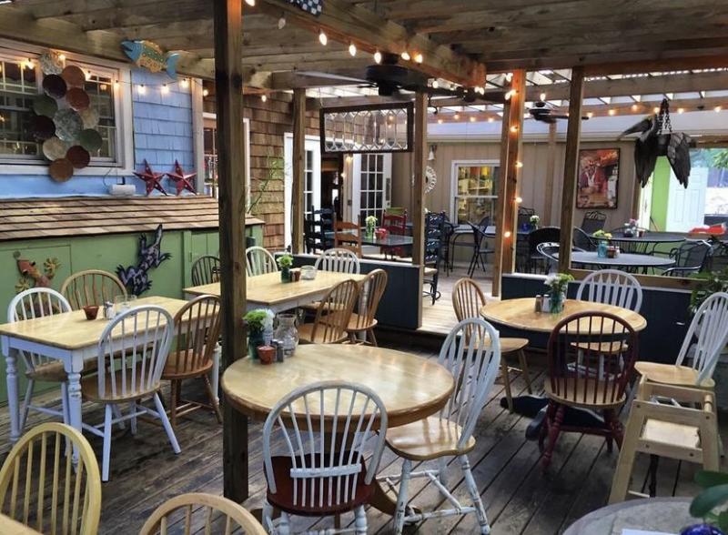 empty Leaping Lizard Cafe restaurant filled with tables and chairs on a porch
