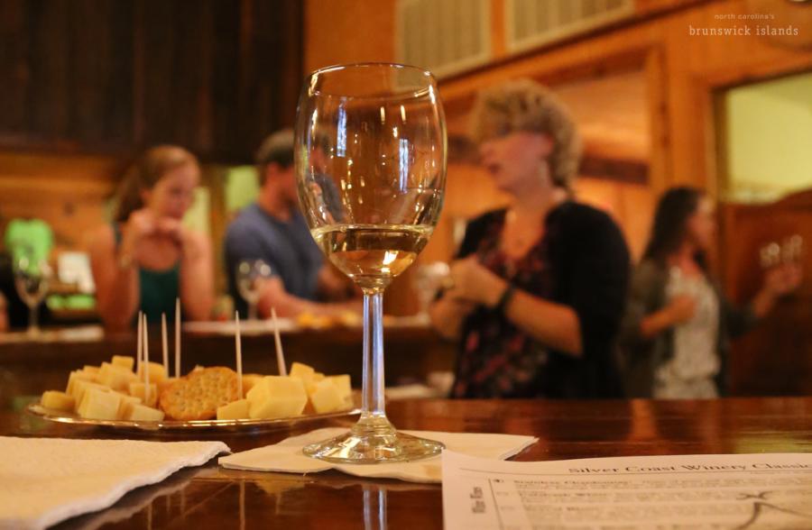 a glass of wine and cheese tray on a countertop