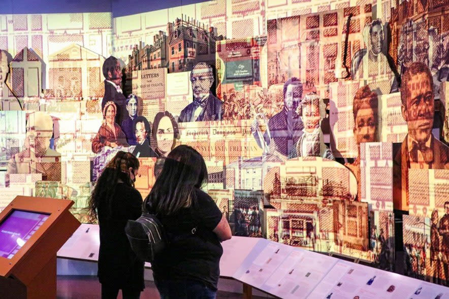 A group of people looking at a wall of art