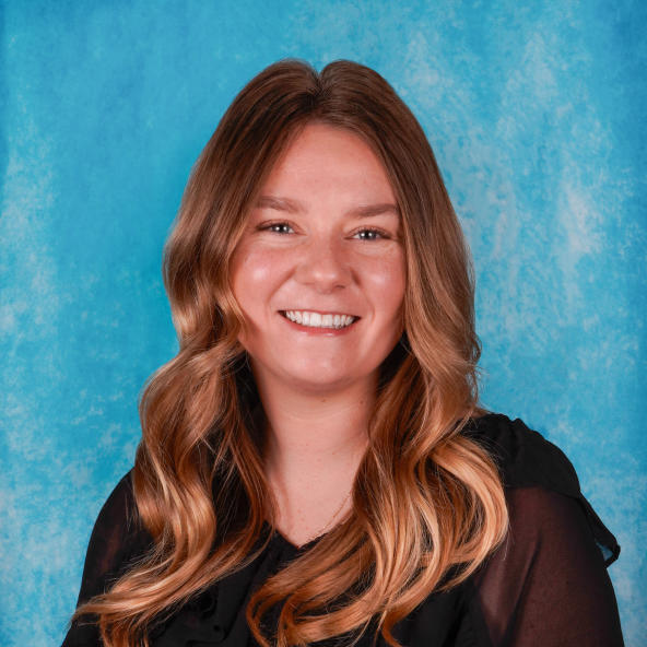 Woman's professional headshot on a blue background.
