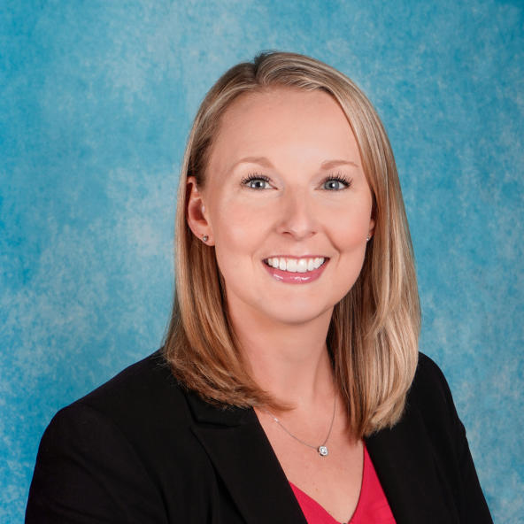 Blonde woman with blue eyes in a professional headshot.