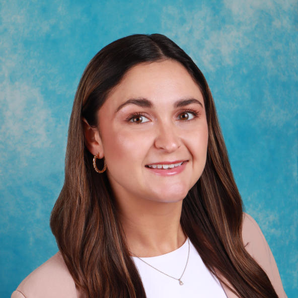 Woman's professional headshot with a blue background.