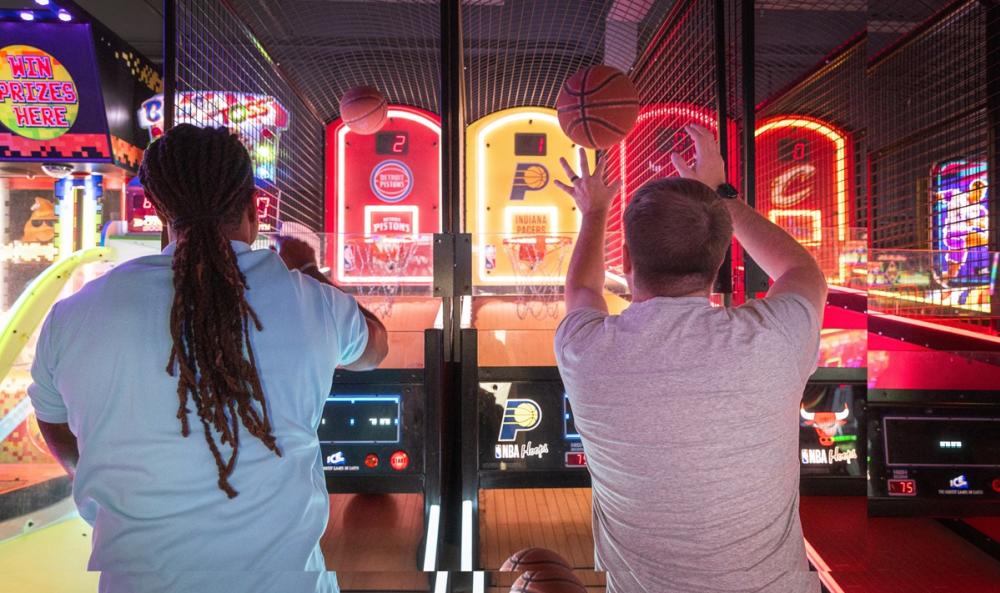 Two men playing arcade basketball.