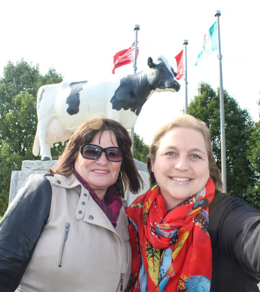 Woman taking a photo with a cow statue