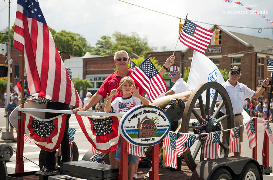 a man and boy waving from a 4th of July parade float in Southport, NC