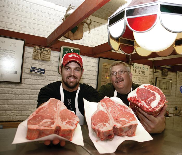 2 Men showing off cuts of beef at Meads Longwood Meat Market In Rockford, IL