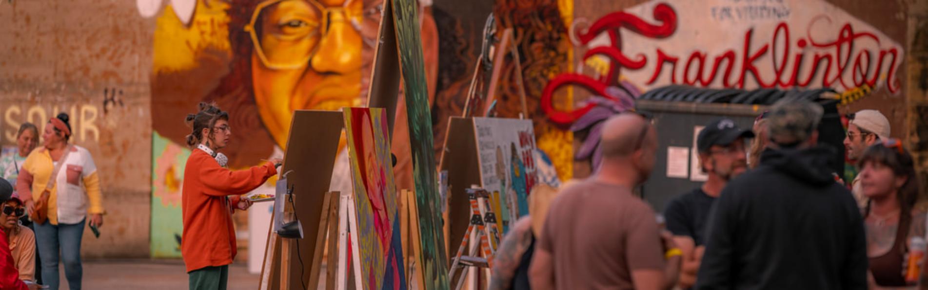 An artist painting at Urban Scawl