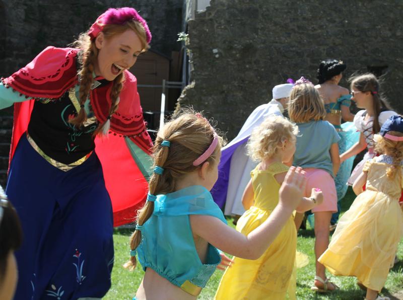 A woman and small girls dresses as princesses