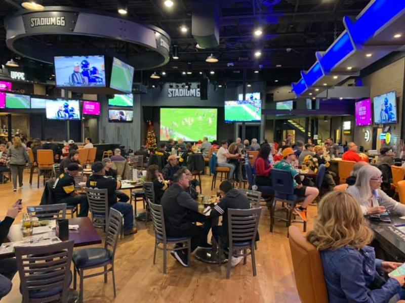People sit at tables inside Stadium66