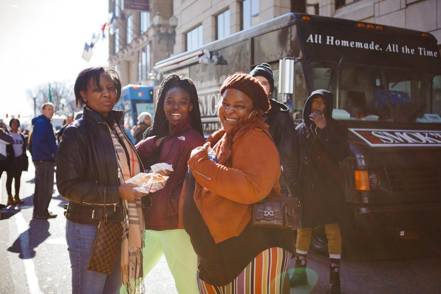 women enjoying food in front of a food truck