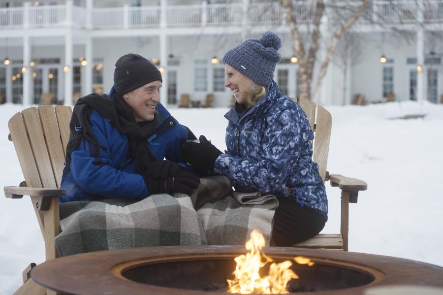 A couple enjoying the firepit by the water