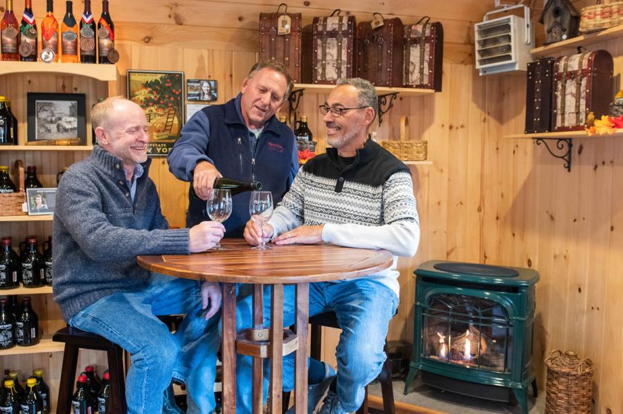 A wine tasting near the fireplace at Raymor Wine Cellars