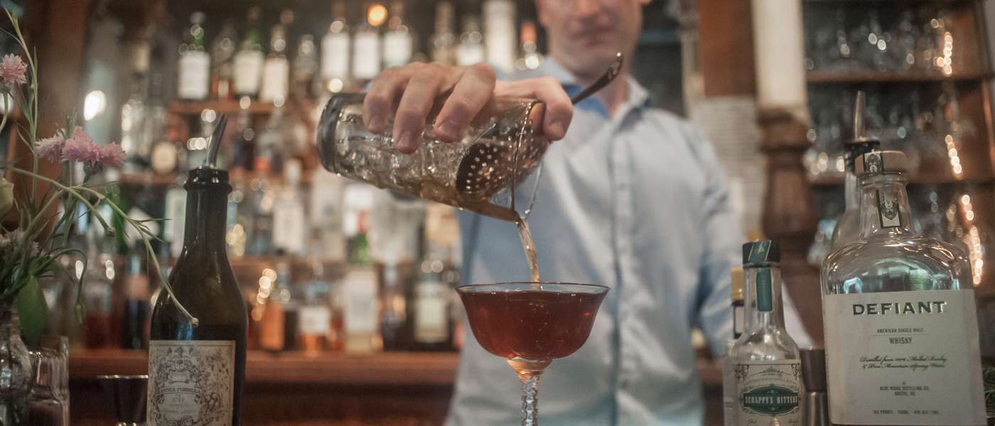 A downtown Columbia SC bartender pouring a whisky drink at the bar