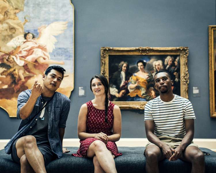 Three young adults explore the RISD Museum.