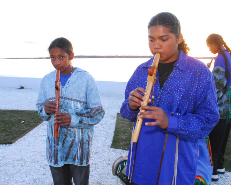 Young men playing flutes