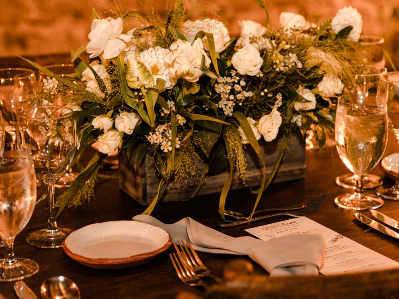 Table setting inside granite walled room with white floral centerpiece