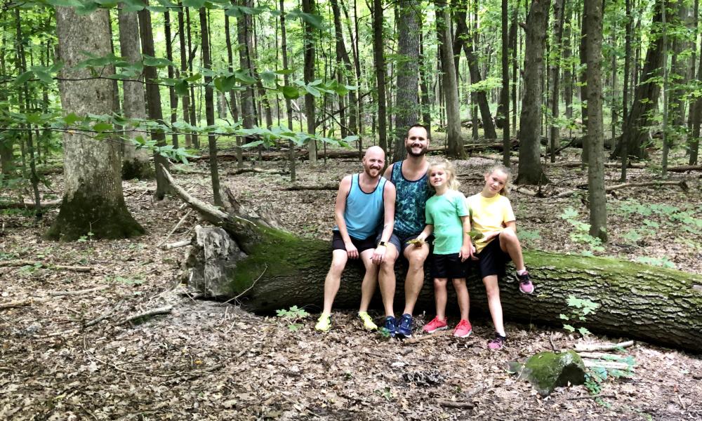 A family takes a break from hiking the Arboretum to post for a photo
